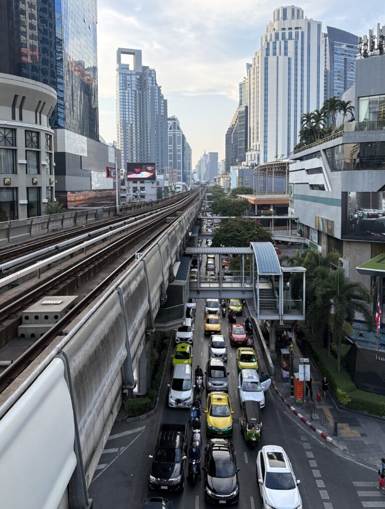 Bangkok BTS railway above busy traffic with city skyline in Thailand
