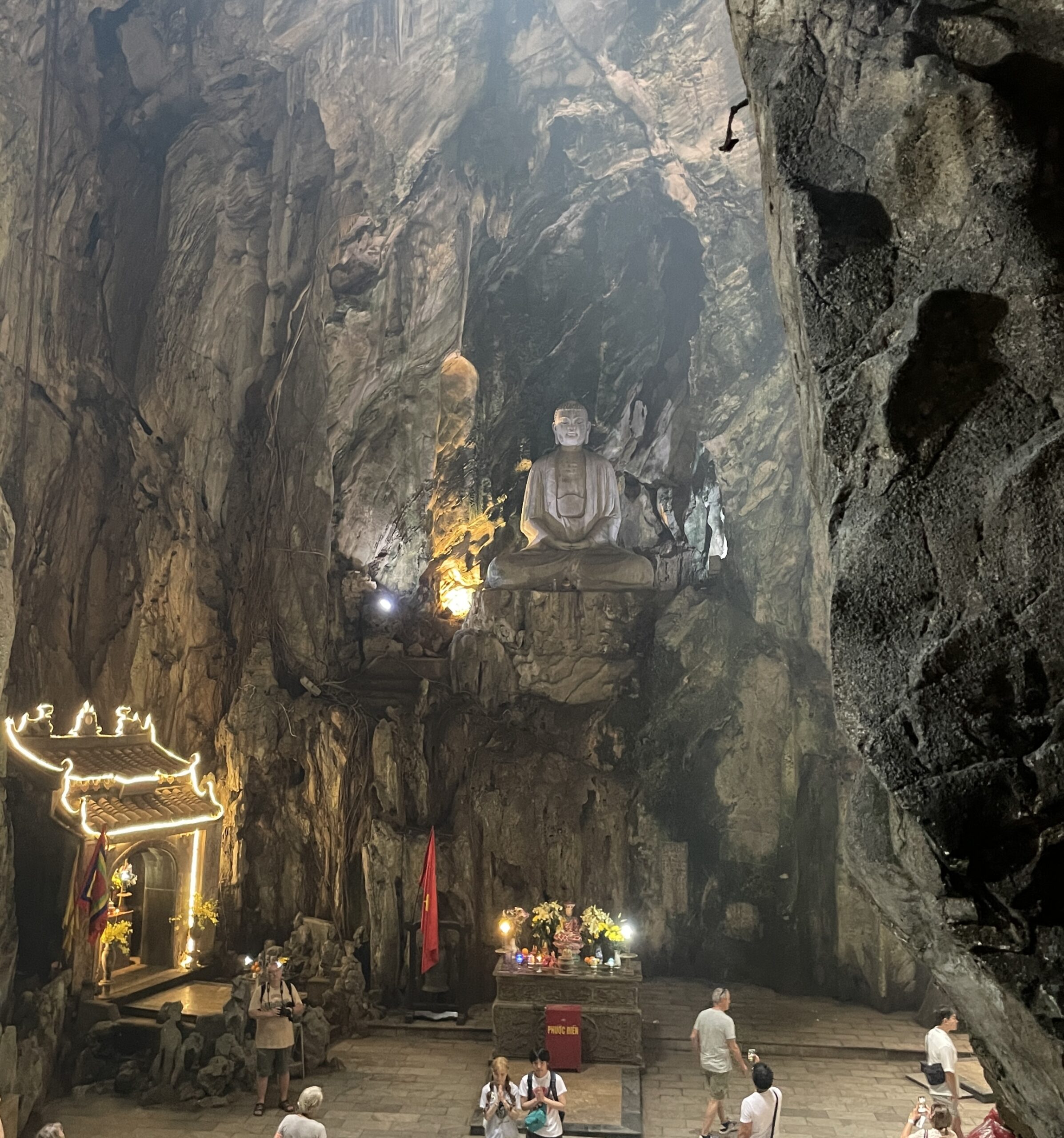 A tourist looking up at a Buddha statue inside one of the caves at the Marble Mountains in Da Nang, Vietnam.