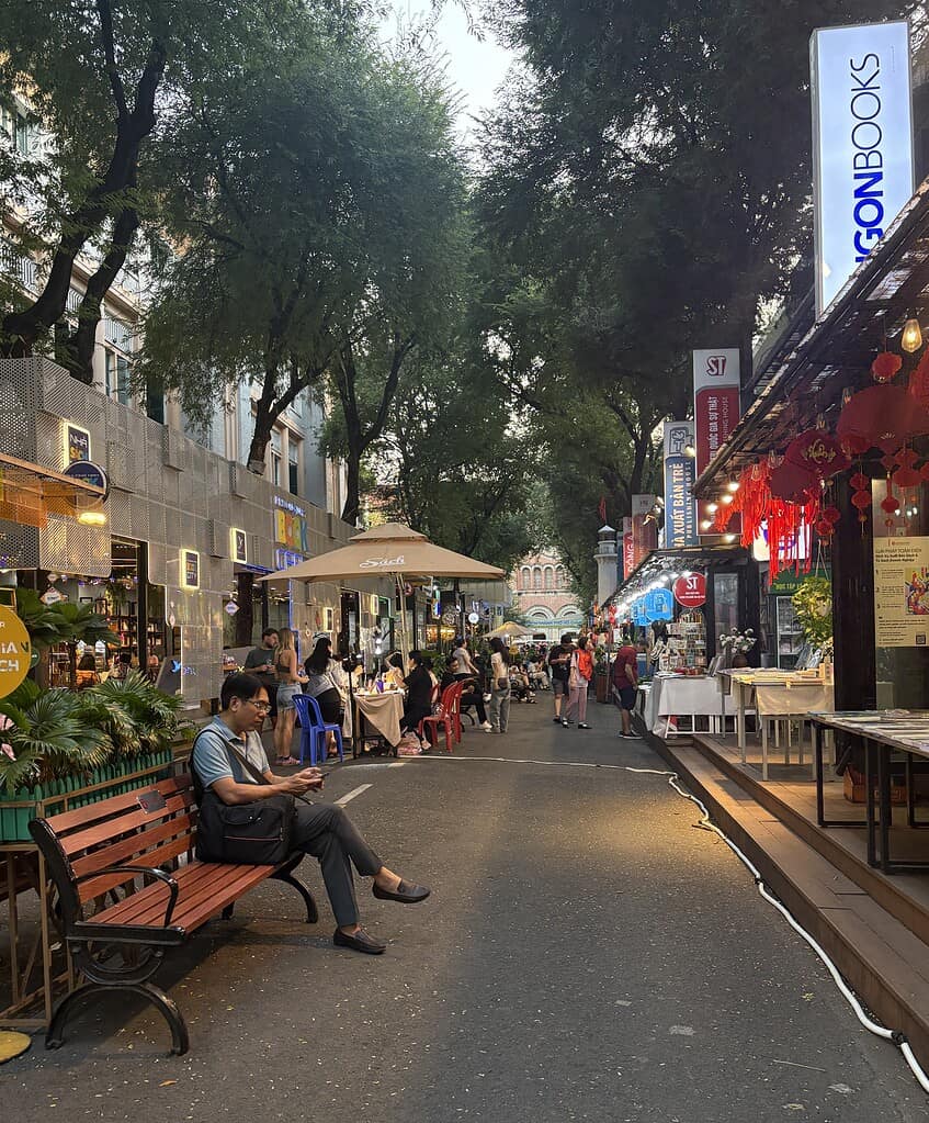 A quiet evening on Book Street in Ho Chi Minh City, showing a man reading along a peaceful, tree-lined street.