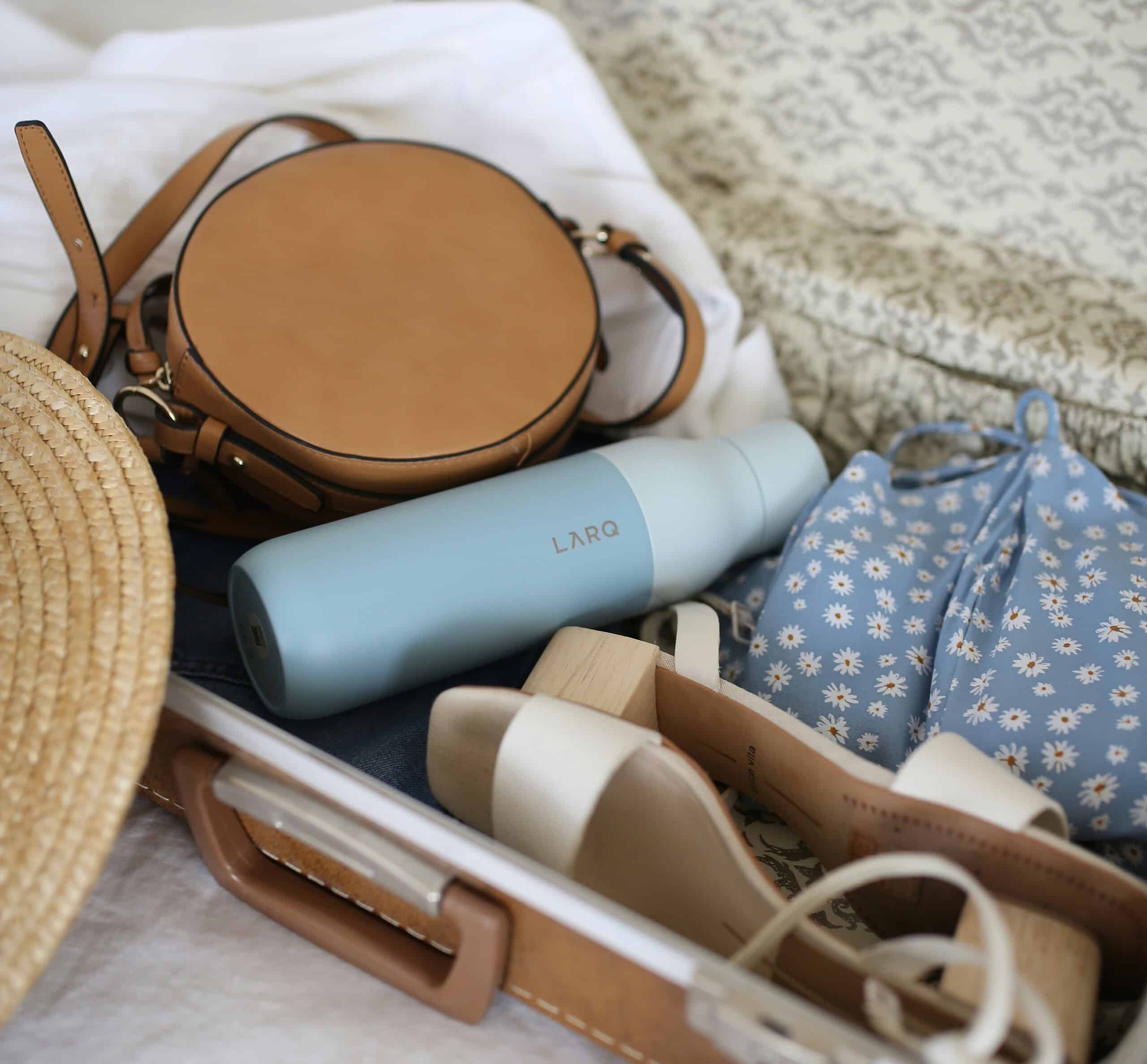 Clothing, shoes, and personal items being packed into a suitcase for a New York City trip