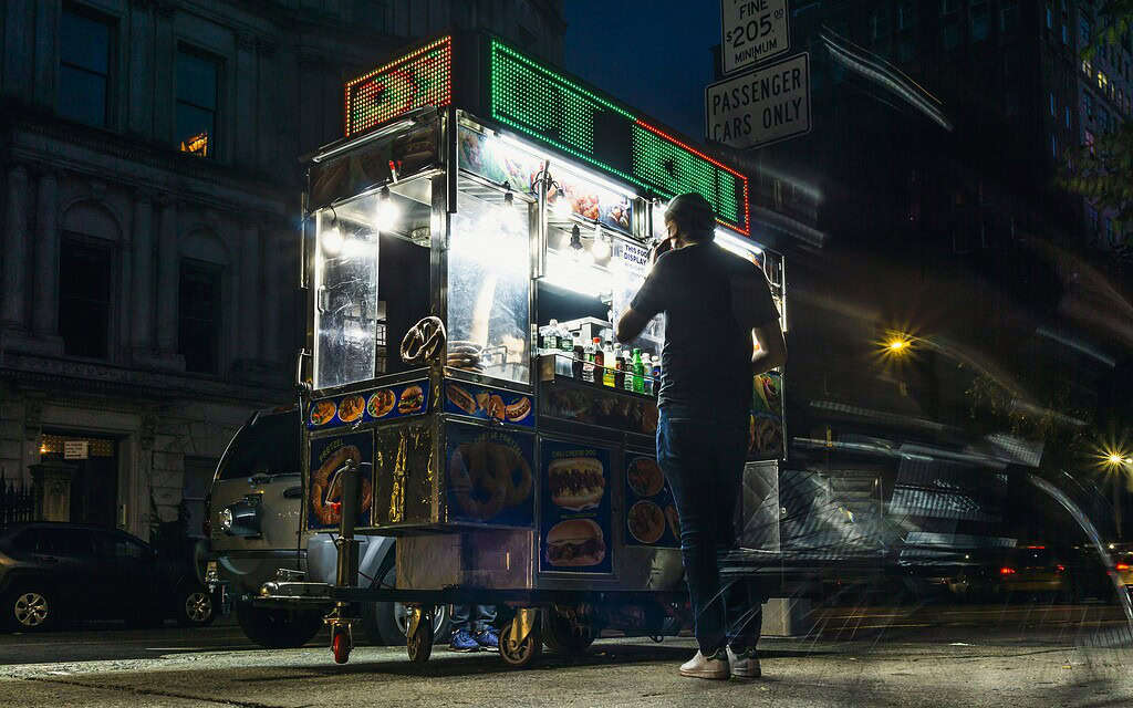 a hotdog food vendor in NYC at night 