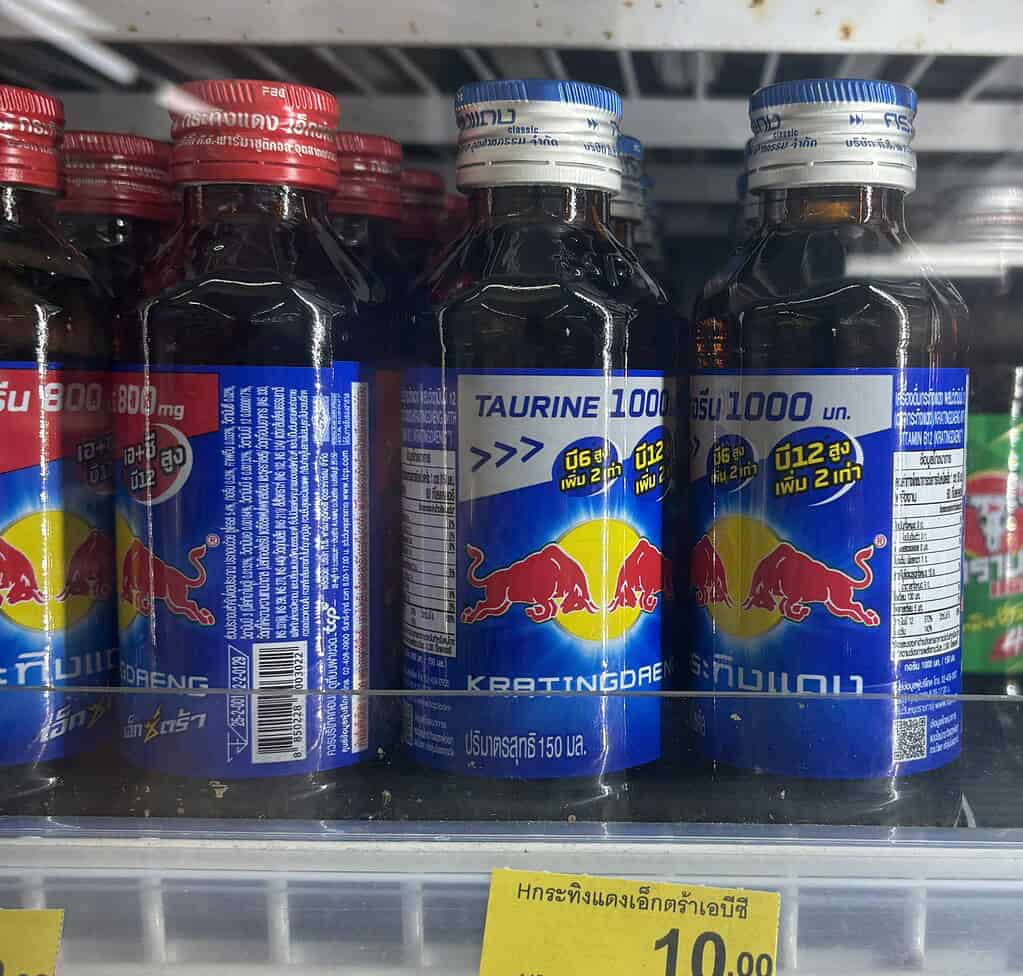 A bottle of Thai Red Bull energy drink from 7-Eleven Thailand, known for its sweet, concentrated flavour and affordable price.