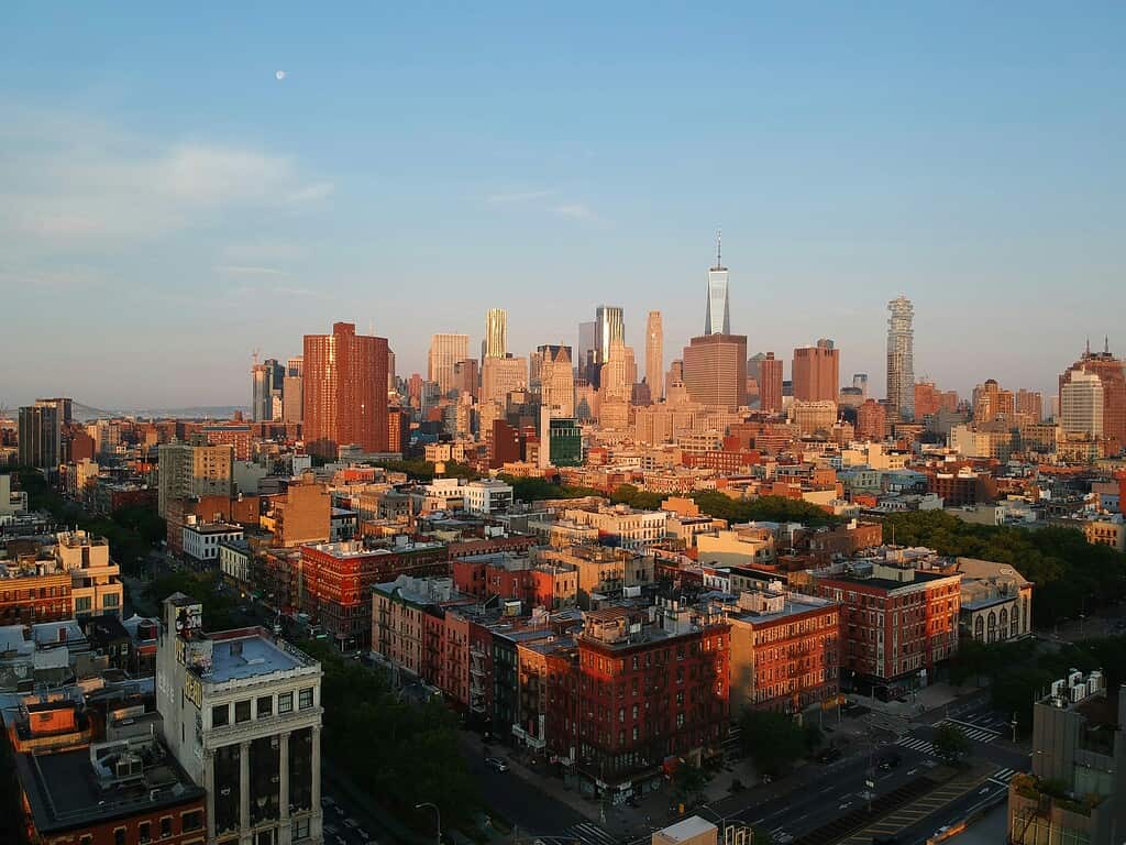 Aerial sunset view of the Lower East Side in NYC with buildings and glowing skyline
