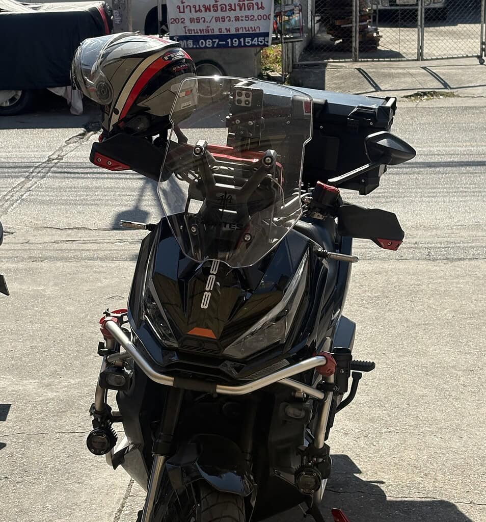 Scooter parked in a lot in Thailand with a black helmet resting on the seat