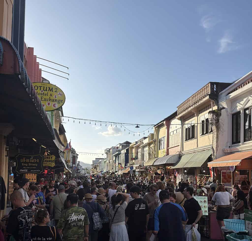 Busy Sunday market in old Phuket town with colorful buildings and clear blue skies