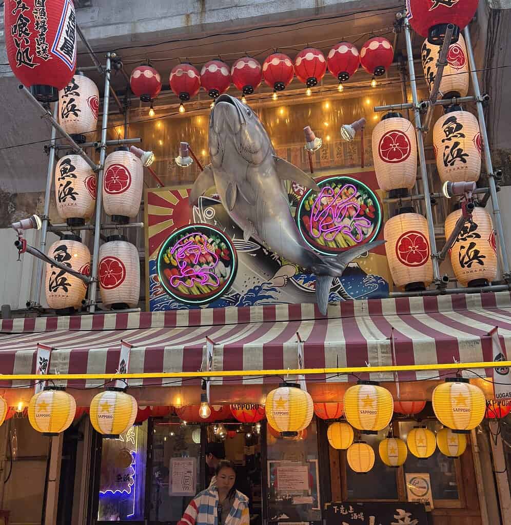 Front entrance of a traditional izakaya restaurant in Tokyo Japan decorated with a large fish sign