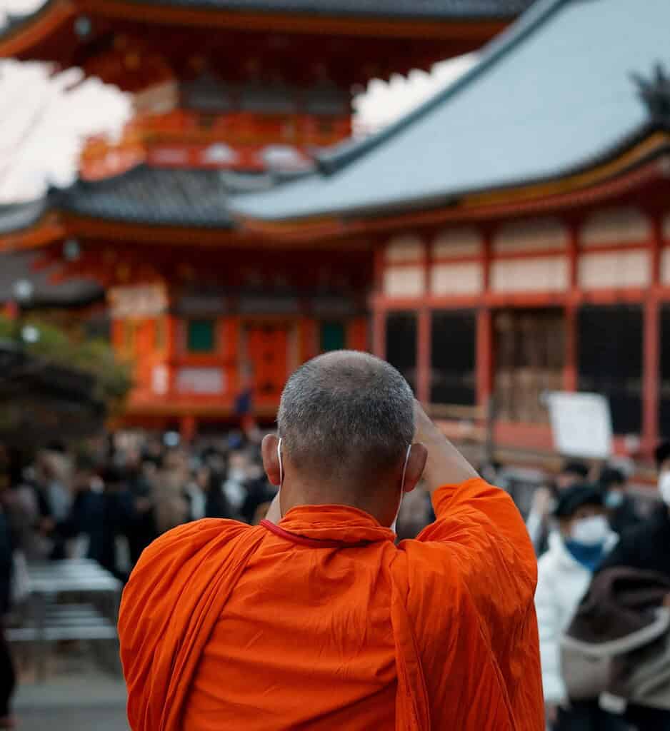 Buddhist monk in traditional robes walking through a temple in Japan