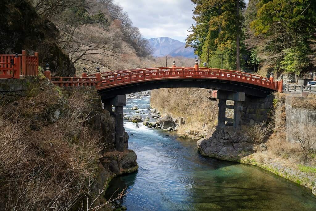 beautiful Japanese style bridge over a river with charming nature in the distance in Nikko, Japan