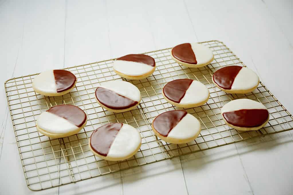 a batch of classic black and White cookies on a tray 