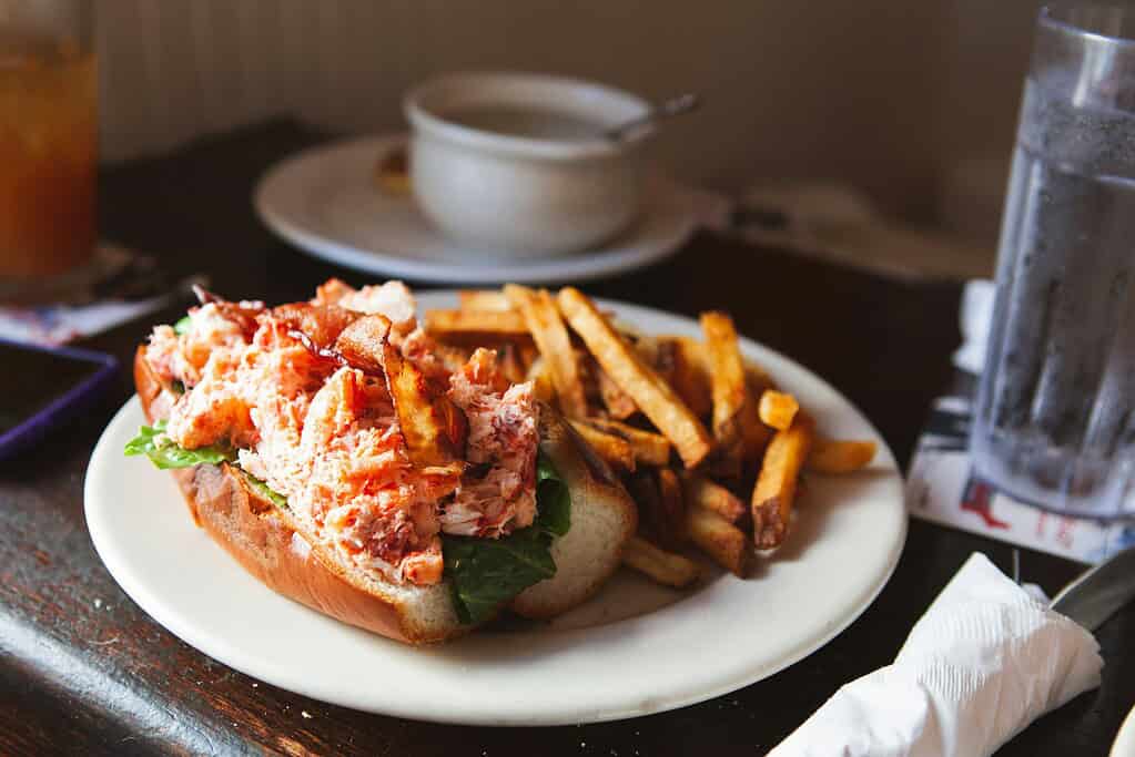 lobster roll being served with french fries