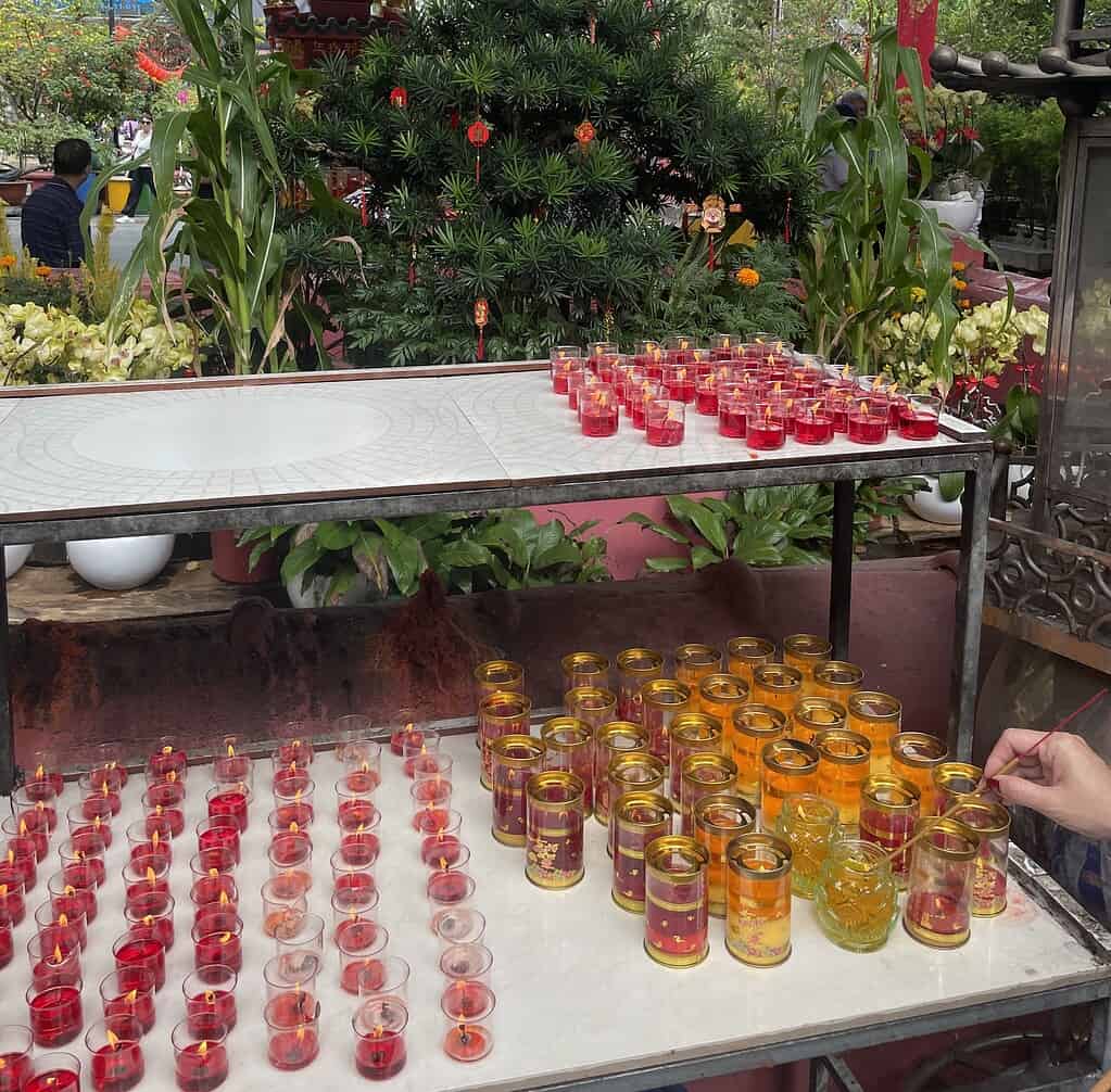 Red and gold candles burning at a Vietnamese temple shrine during Tet celebrations in Ho Chi Minh City Vietnam