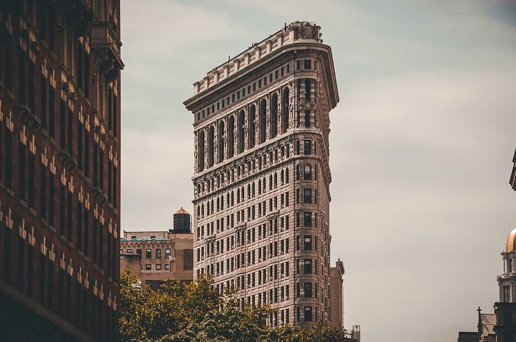 view of the flat iron building on a cloudy day in NYC
