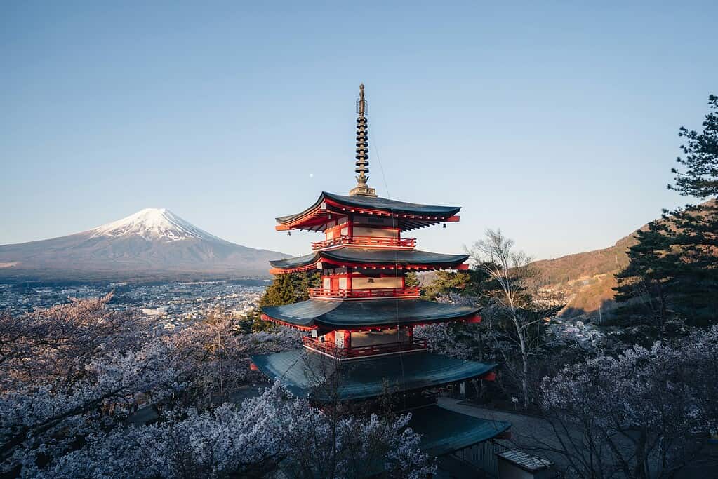 a temple in the winter with Mount Fuji in the distance during winter time 