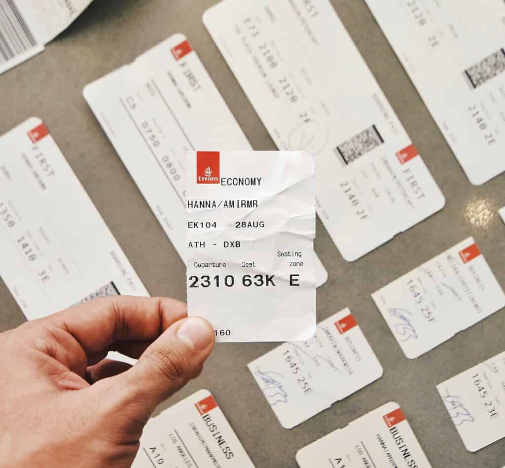 a person holding a airplane ticket for an Emirates flight