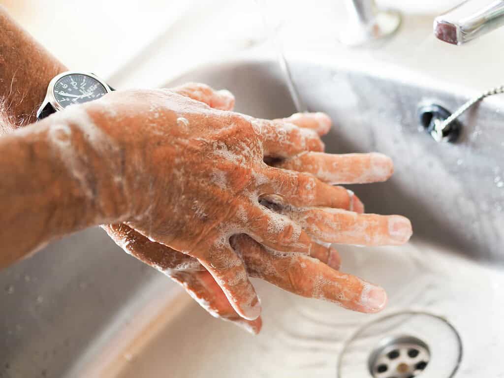 a man washing his hands over the sink
